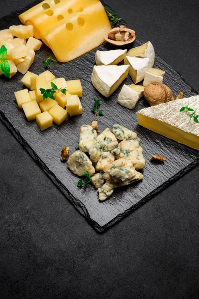 Vários tipos de queijo - brie, camembert, roquefort e cheddar em concreto — Fotografia de Stock