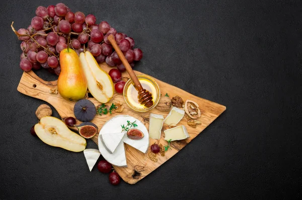 Fatia de queijo brie ou camembert francês e pêra em tábua de madeira — Fotografia de Stock