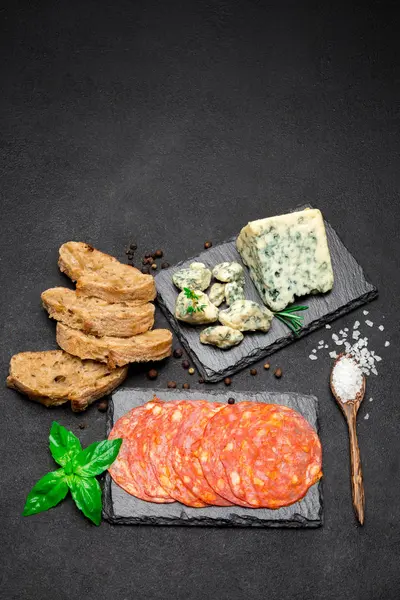 Fatia de queijo Roquefort e salsicha chouriço em tábua de pedra — Fotografia de Stock