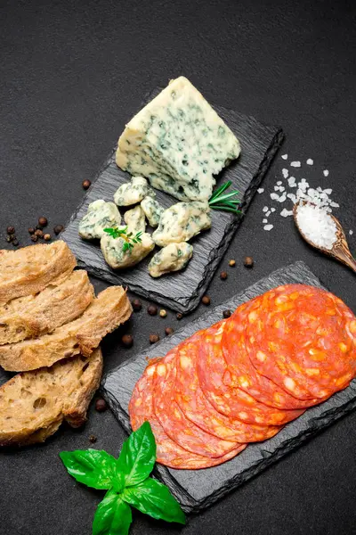 Fatia de queijo Roquefort e salsicha chouriço em tábua de pedra — Fotografia de Stock