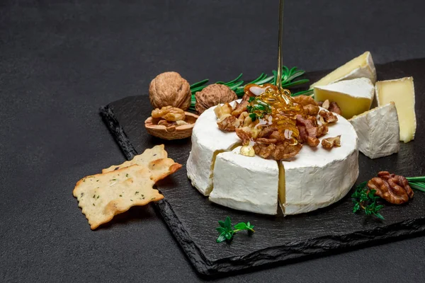 Queijo de camembert e nozes em tábua de pedra — Fotografia de Stock