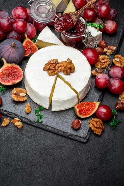 Sýr camembert a vlašské ořechy na kámen slouží desky — Stock fotografie