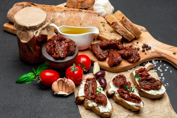 Bruschetta with Canned Sundried or dried tomato halves on craft pepper — Stock Photo, Image