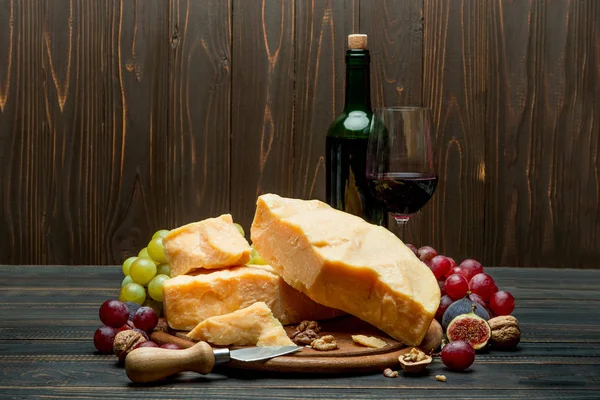 Pedaços de queijo parmesão ou parmigiano, uvas e vinho — Fotografia de Stock