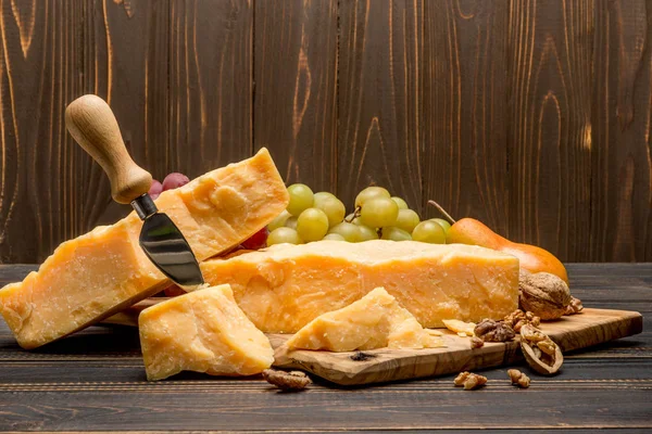 Trozos de queso parmesano o parmesano y uvas — Foto de Stock