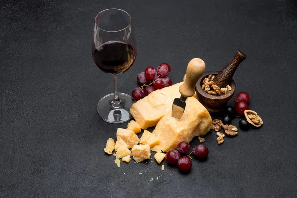 Pieces of parmesan or parmigiano cheese, wine and grapes — Stock Photo, Image