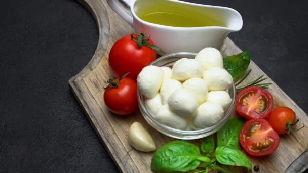 Состав для салата капрезе - моцарелла, помидоры, листья базилика, оливковое масло — стоковое видео