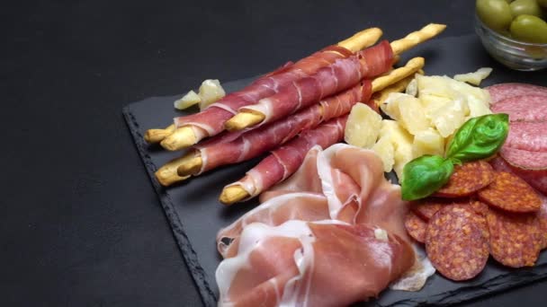 Видео итальянской мясной плиты - нарезанная ветчина, колбаса, гриссини и пармезан — стоковое видео
