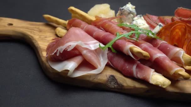 Video von italienischem Fleischteller - Schinken, Wurst, Grissini und Parmesan in Scheiben geschnitten — Stockvideo