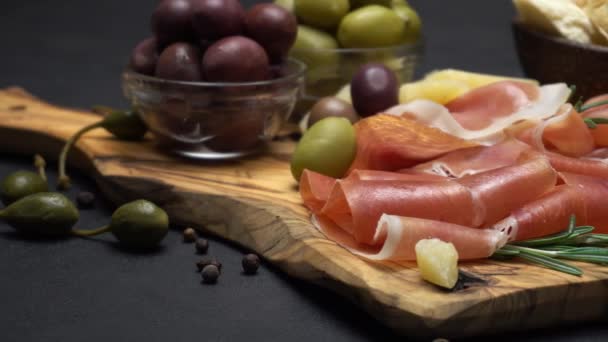 Prosciutto fatiado em uma placa de madeira e pão — Vídeo de Stock