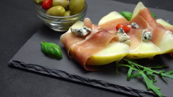 Aufgeschnittener Prosciutto und Melone auf einem Steinbrett — Stockvideo