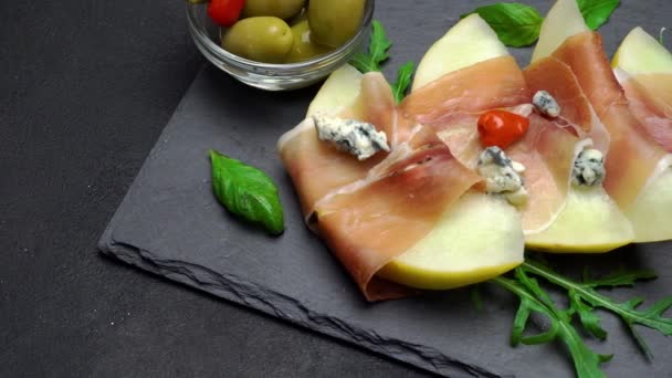 Tranches de prosciutto et de melon sur une planche de pierre — Video