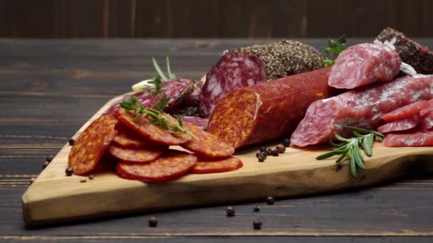 Salami and chorizo sausage close up on wooden background — Stock Video