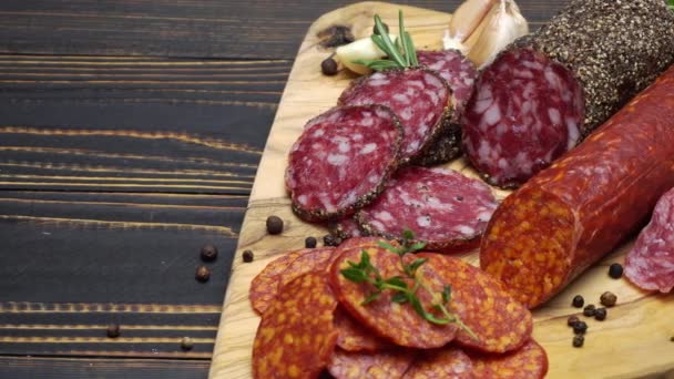 Salami and chorizo sausage close up on wooden background — Stock Video