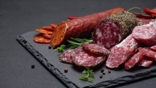 Salami and chorizo sausage close up on stone serving board — Stock Video