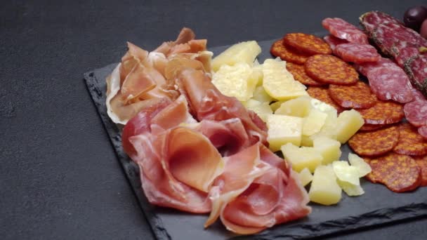 Prosciutto w plasterkach, ser i kiełbasa salami na tablicy do serwowania kamienia — Wideo stockowe