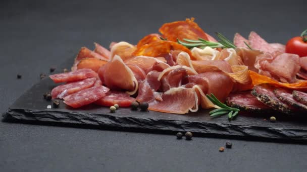 Fleischteller - geschnittener Prosciutto und Salamiwurst auf Steinplatte — Stockvideo