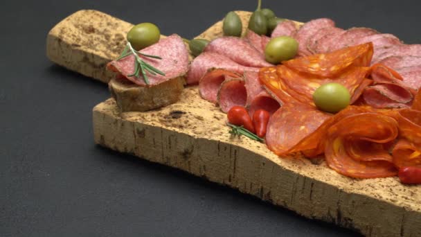 Salami und Chorizo-Wurst hautnah auf dunklem Betongrund — Stockvideo
