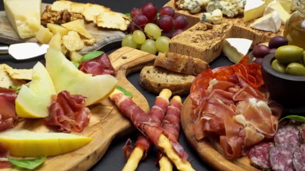 Hús és a sajt tál antipasti snack a Prosciutto, a sárgadinnye, a szőlő és a sajt — Stock videók