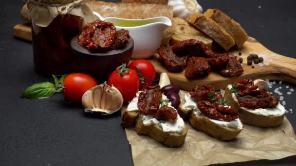 Bruschetta con mitades de tomate enlatado o seco sobre pimienta artesanal — Vídeo de stock