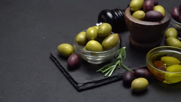 Aceitunas negras y verdes y aceite sobre tabla de servir de piedra — Vídeos de Stock