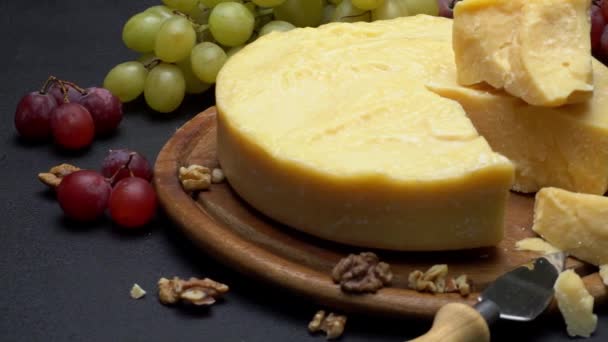 Hele ronde hoofd Parmezaanse kaas, wijn en druiven — Stockvideo