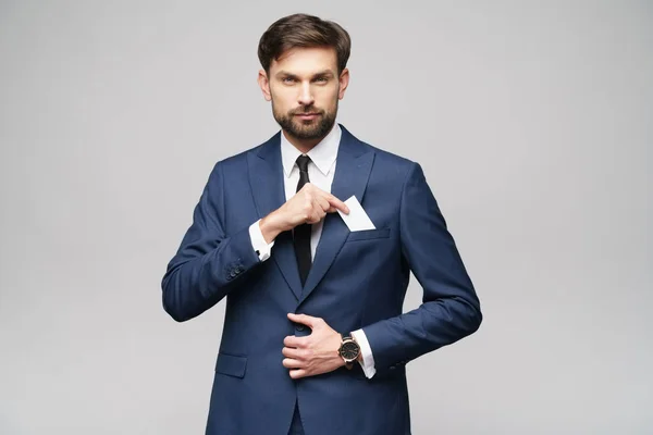 Studio photo of young handsome businessman wearing suit holding business card — ストック写真