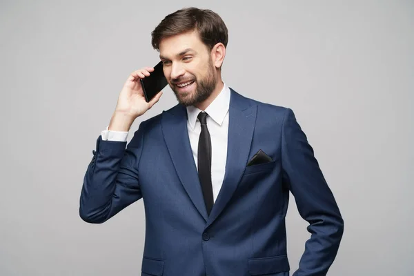 Uomo d'affari che parla al telefono isolato su sfondo grigio — Foto Stock