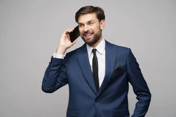 Businessman talking on the phone isolated over grey background — Stock Photo, Image