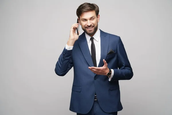 Affärsman talar på telefonen isolerad över grå bakgrund — Stockfoto