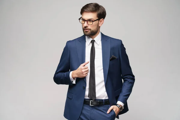 Retrato de un joven y guapo hombre de negocios elegante con gafas sobre fondo gris —  Fotos de Stock