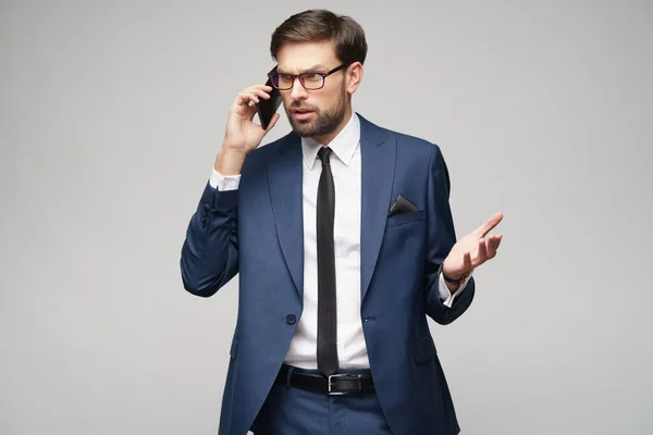 Üzletember beszél telefonon elszigetelt szürke háttér — Stock Fotó