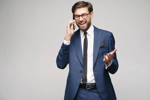 Hombre de negocios hablando por teléfono aislado sobre fondo gris —  Fotos de Stock
