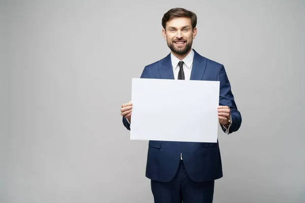 Jungunternehmer mit leeren Schildern vor grauem Hintergrund — Stockfoto