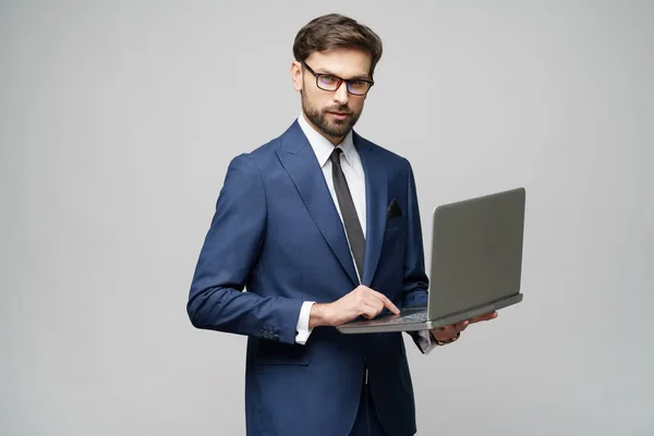 Молодой привлекательный бизнесмен держит ноутбук с чистым экраном — стоковое фото