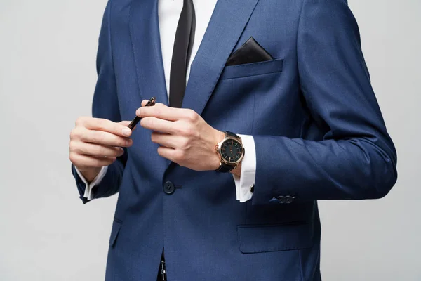 Close-up photo of young businessman wearing suit holding pen — ストック写真