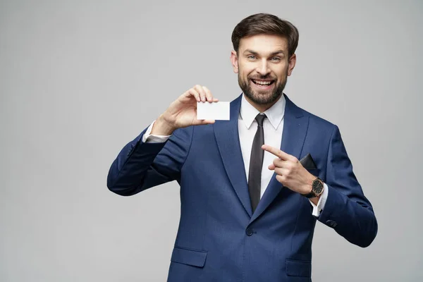 Joven hombre de negocios guapo tenencia de negocios o tarjeta de crédito —  Fotos de Stock