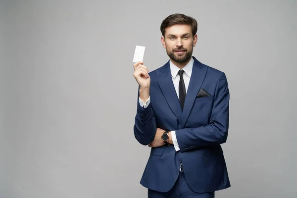 Jovem empresário bonito segurando negócio ou cartão de crédito — Fotografia de Stock