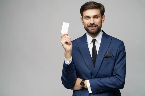 Joven hombre de negocios guapo tenencia de negocios o tarjeta de crédito —  Fotos de Stock