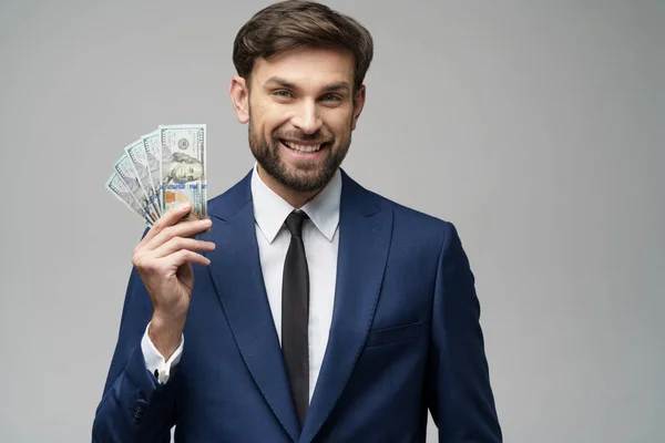 Jeune homme d'affaires beau tenant des billets en dollars américains — Photo