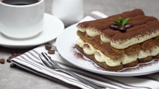 Classic tiramisu dessert on ceramic plate, milk or cream and cup of coffee on concrete background — 비디오