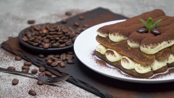 Postre tiramisú clásico sobre plato de cerámica sobre fondo de hormigón — Vídeo de stock