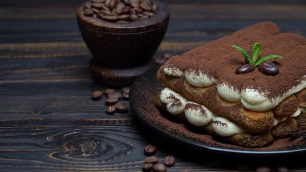 Класичний десерт тірамісу на керамічній тарілці на дерев'яному фоні — стокове відео