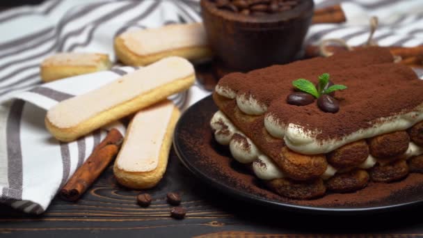 Klasický tiramisu dezert na keramické desky a savoiardi sušenky na dřevěném pozadí — Stock video