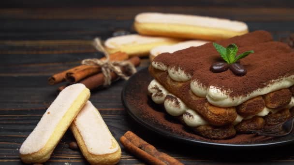 Classic tiramisu dessert on ceramic plate and savoiardi cookies on wooden background — Stock Video