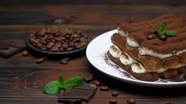 Postre tiramisú clásico sobre plato de cerámica sobre fondo de madera — Vídeo de stock