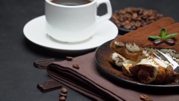 Порция классического десерта тирамису и чашка свежего кофе эспрессо на бетонном фоне — стоковое видео