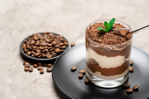 Postre tiramisú clásico en una taza de vidrio sobre fondo de hormigón —  Fotos de Stock