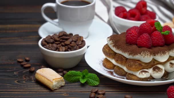Portion of Classic tiramisu dessert with raspberries, savoiardi cookies and cup of espresso coffee — Stockvideo