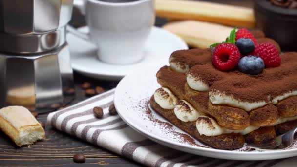 Tiramisu dessert with raspberries. blueberries, cup of espresso and coffee maker on wood — Stock Video